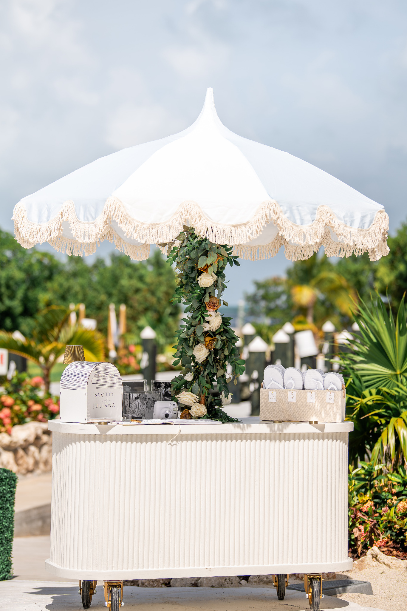 White Cart Haus cart beneath a fringed umbrella at an outdoor celebration